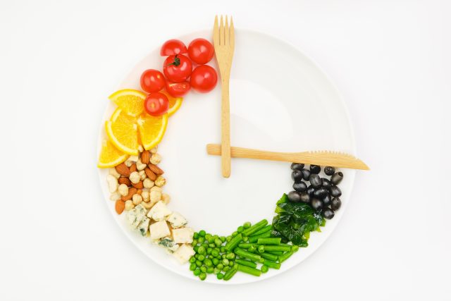 Kuva lautasesta, jossa on kasviksia ja kellotaulu